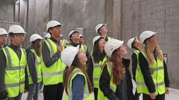 Students in a lab in Iceland--wearing hard hats and bright green vest--looking up off camera