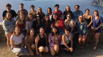 Group photo of students with a backdrop of a body of water