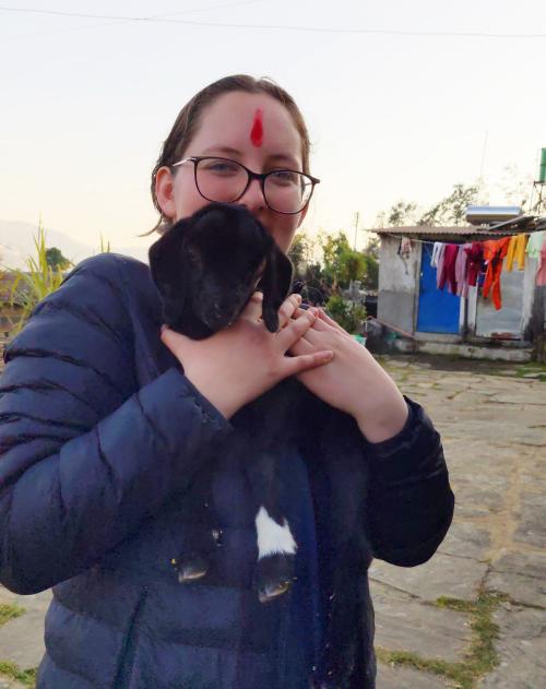 A student holding a baby goat.