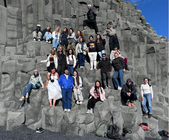 Jessica and her cohort stand for a picture on rocks in Scotland.