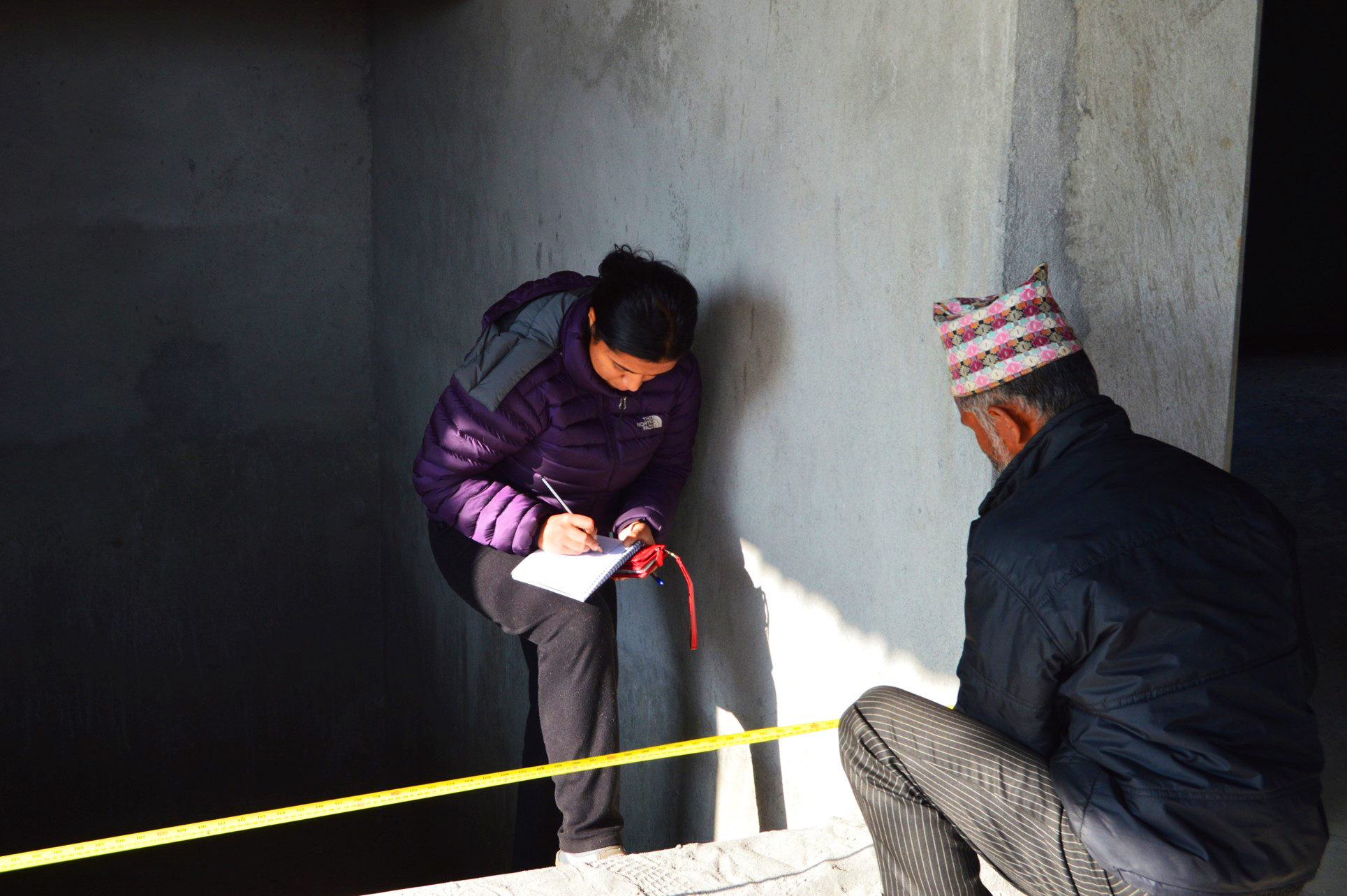 Student sitting down taking measurements.