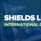 On a dark blue background with a lighter blue unfolded map of the world with a flag marking UC Davis's location, a triangular flag reads, "UC Davis". The wording on the image in white and light green reads "Shields Library International Open House." 
