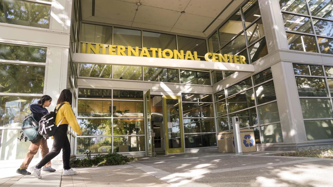 Two students walk towards the entrance of the International Center building on the UC Davis campus.